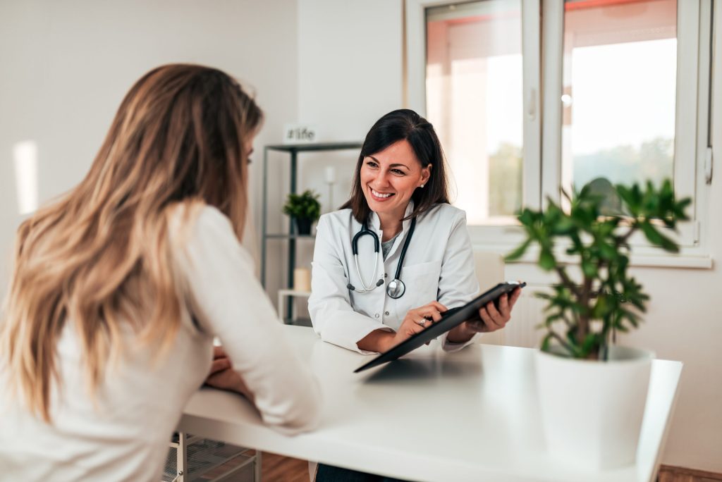 Female doctor explaining diagnosis to her young patient. (models)