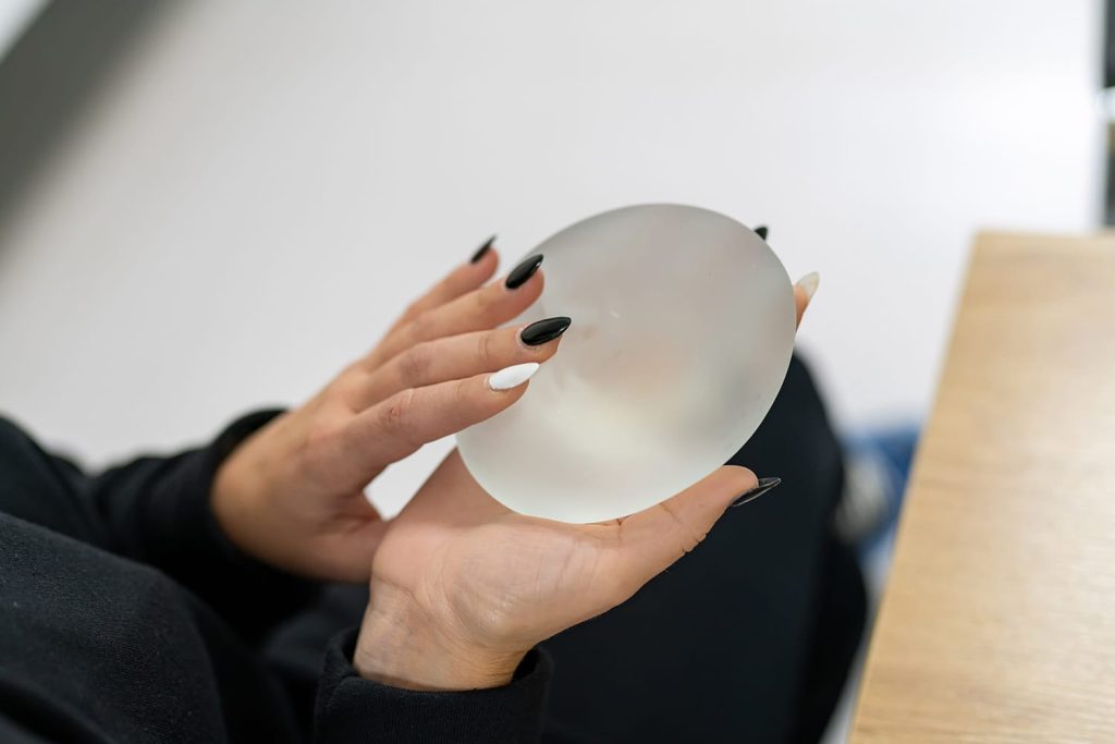 close-up of a woman holding a breast implant