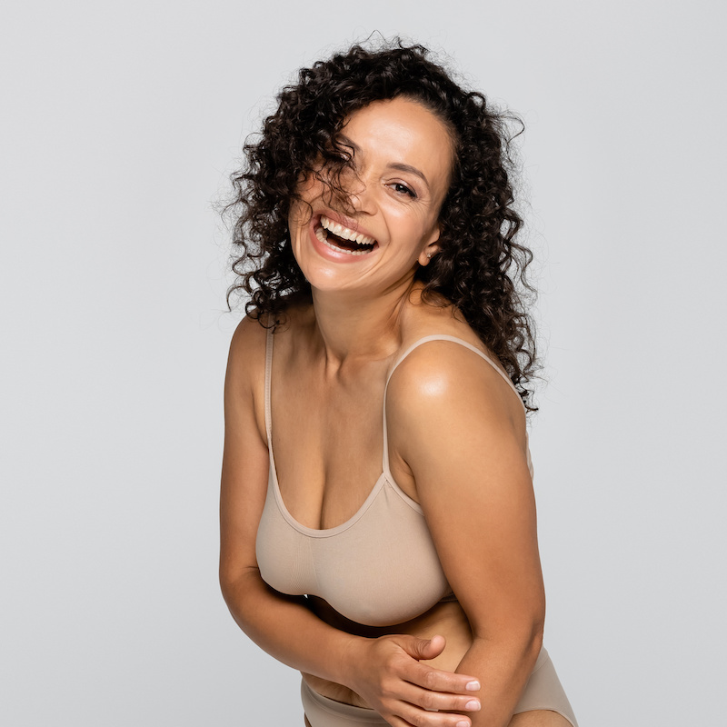 happy smiling woman in nude colored bra